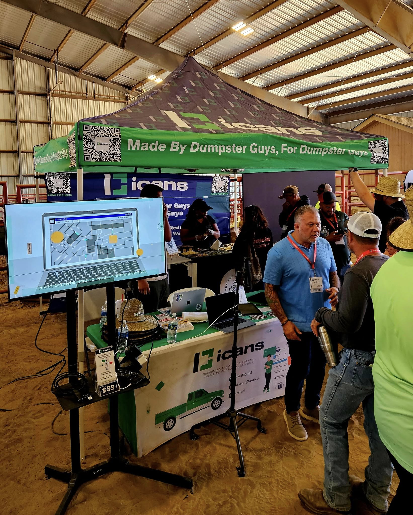 Operators in conversation at the iCANS booth during Dumpster Expo